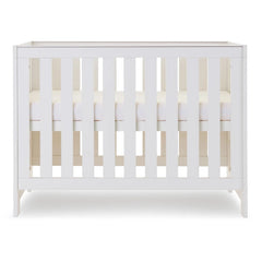 Obaby Nika MINI Cot Bed - White Wash side view, showing mattress base at highest level